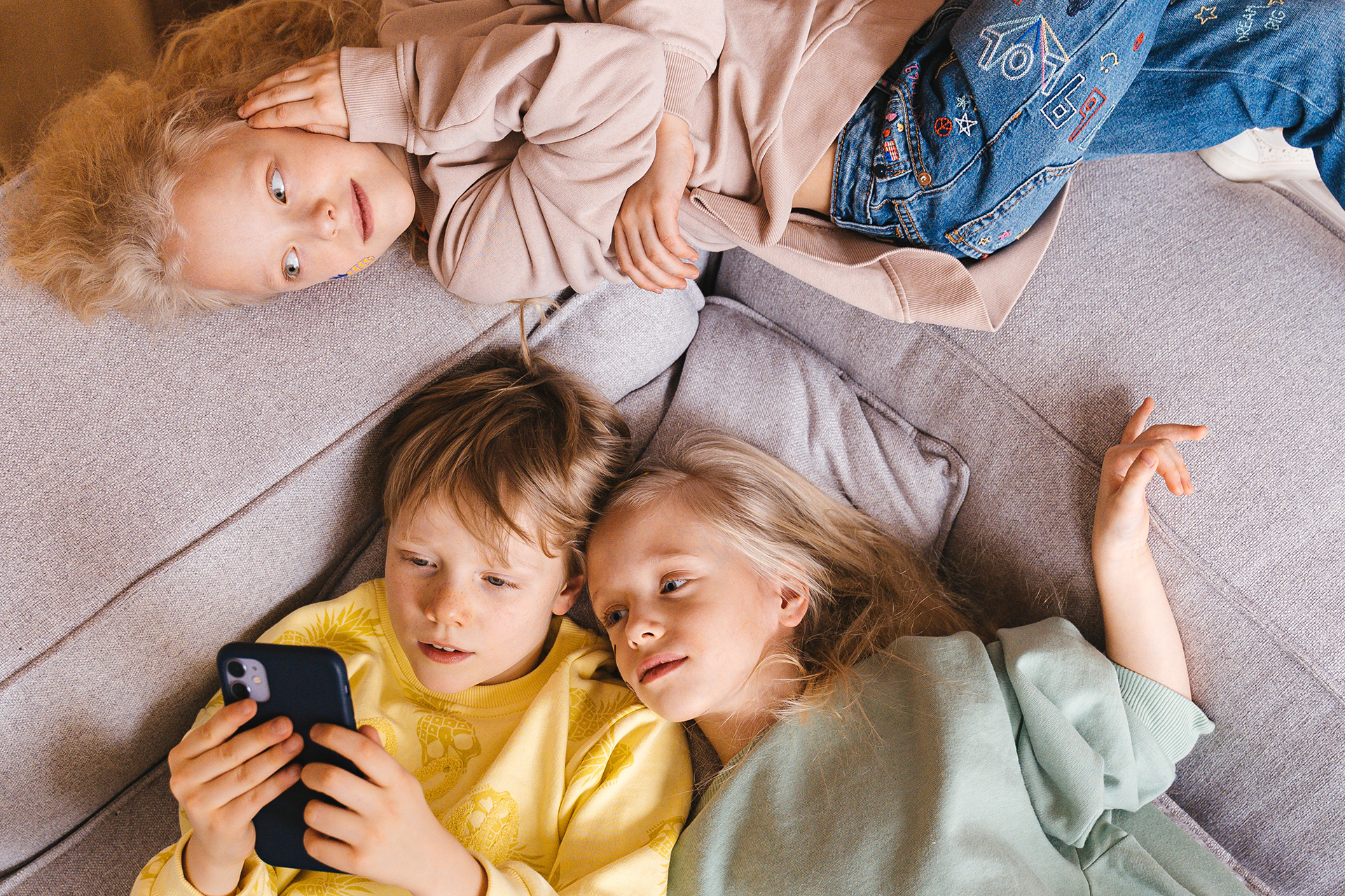 Balancing Screen Time and Healthy Development: Kids looking at a smart phone